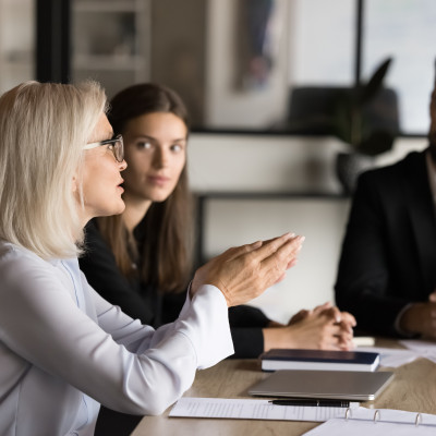Professionals sitting at conference table talking.